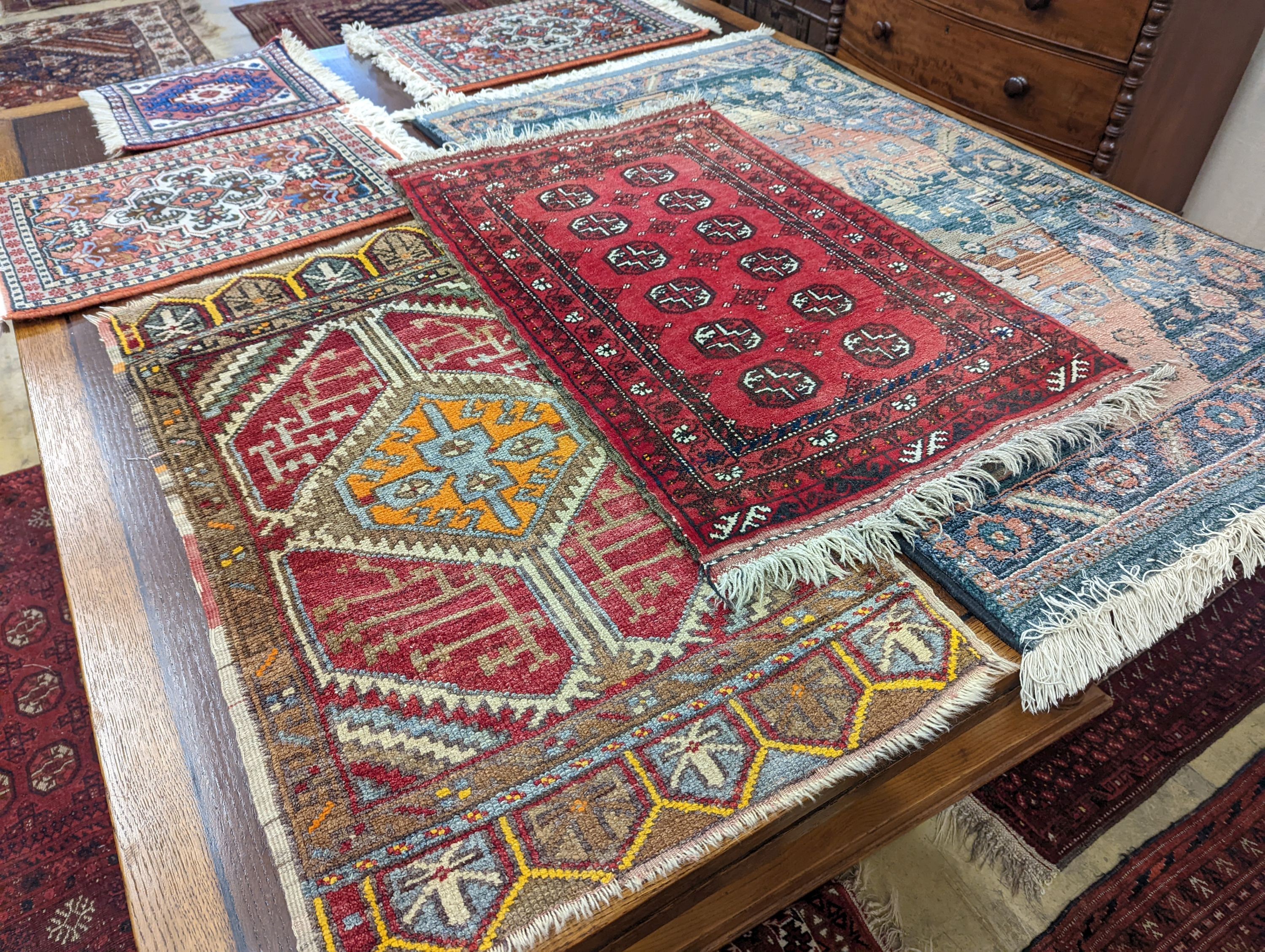 A Caucasian red ground mat, a Bokhara mat, three others and a blue ground rug, largest 136 x 80cm (6)